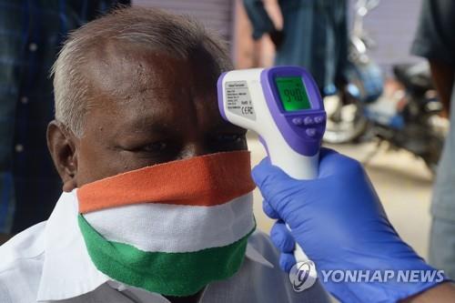 인도 첸나이에서 의료진이 코로나19 감염 여부를 파악하기 위해 한 남성의 열을 체크하는 모습. [AFP=연합뉴스]