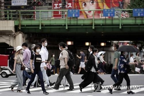마스크를 쓴 채 도쿄 거리의 횡단보도를 건너는 사람들. [AP=연합뉴스 자료사진]