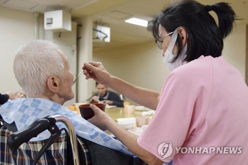 일본 도쿄의 한 노인복지시설에서 직원이 고령자의 식사를 돕고 있다. [교도=연합뉴스 자료사진] 