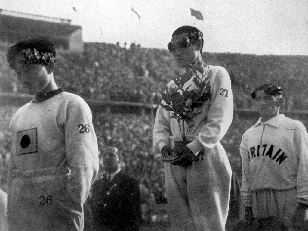 1936년 8월 9일 손기정(가운데)이 베를린 올림픽 마라톤에서 우승한 후 시상대에서 월계수 화분을 들고 서 있다. 같은 대회에서 3위로 입상한 남승룡(화면 왼쪽)과 2위로 입상한 어니스트 하퍼가 함께 시상대에 올랐다. [교도=연합뉴스 자료사진]