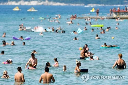 크로아티아 해변에서 해수욕을 즐기는 관광객들