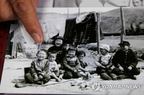 (아키타 로이터=연합뉴스) 스가 요시히데 관방장관의 동창생이 11일 어린 시절 사진에서 스가를 손가락으로 가리키고 있다.