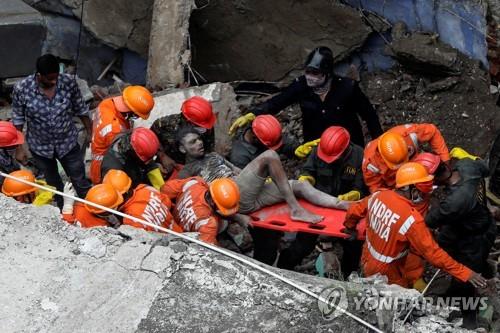 21일 인도 뭄바이 인근 비완디의 무너진 건물에서 구조대가 생존자를 구해내고 있다. [로이터=연합뉴스]