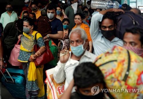 인도 뭄바이에서 마스크를 쓰고 기차역을 빠져나가는 승객. [로이터=연합뉴스]