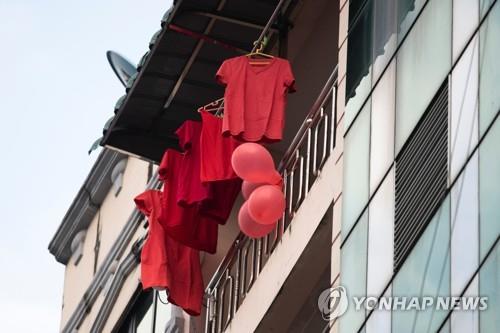쿠데타 항의 표시로 양곤시 아파트 베란다에 걸린 빨간 풍선과 티셔츠. 2021.2.5