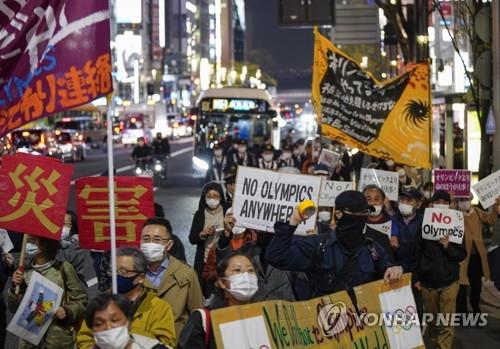 (도쿄 EPA=연합뉴스) 신종 코로나바이러스 감염증(코로나19) 상황에서 추진되는 2020도쿄올림픽 개최에 반대하는 일본 시민들이 25일 도쿄 도심에서 '노 올림픽' '올림픽보다 생명이 중요' 등의 문구가 적힌 손팻말을 들고 시위하고 있다. 