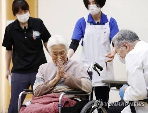 (이타미 교도=연합뉴스) 일본 효고현 이타미에서 12일 한 노인이 신종 코로나바이러스 감염증(코로나19) 백신을 맞은 뒤 감사 인사를 하고 있다. 일본은 이날부터 65세 이상 고령자 3천600만 명을 대상으로 코로나19 백신 접종을 시작했다. sungok@yna.co.kr