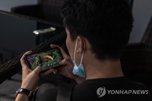 스마트폰으로 텐센트의 왕자영요 게임 하는 중국인