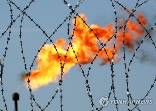 러시아 국영 석유업체 로즈네프트 공장의 철조망 뒤편 가스 화염