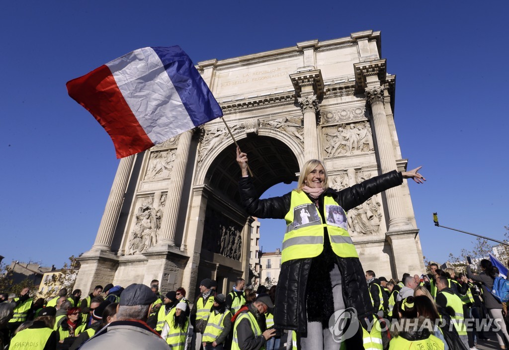 지난 12월 29일 프랑스 파리 개선문 앞에서 열린 노란 조끼 시위에서 여성 참석자가 프랑스 국기인 삼색기를 흔들고 있다. [AP=연합뉴스 자료사진] 