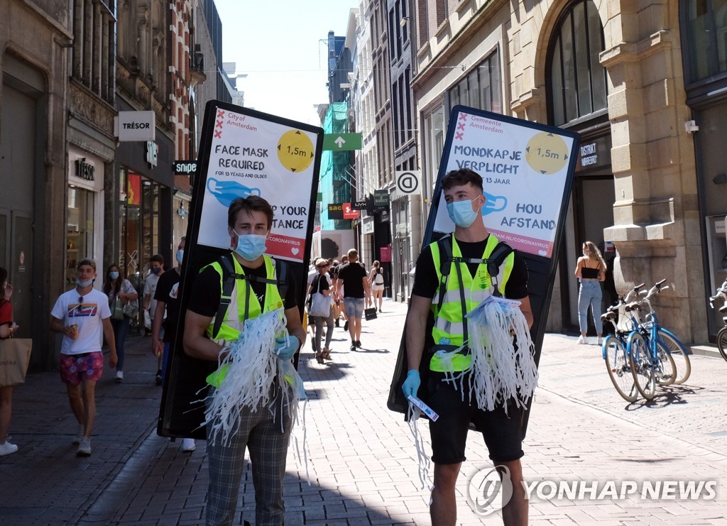 지난 8월 네덜란드 암스테르담에서 사람들에게 마스크를 나눠주고 있는 모습. [AP=연합뉴스 자료사진]