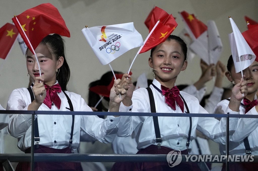 20일 베이징에서 열린 2022 베이징 동계올림픽 성화 환영 행사에서 어린이들이 국기와 2022 베이징 올림픽 깃발을 흔들고 있다. [AP=연합뉴스]