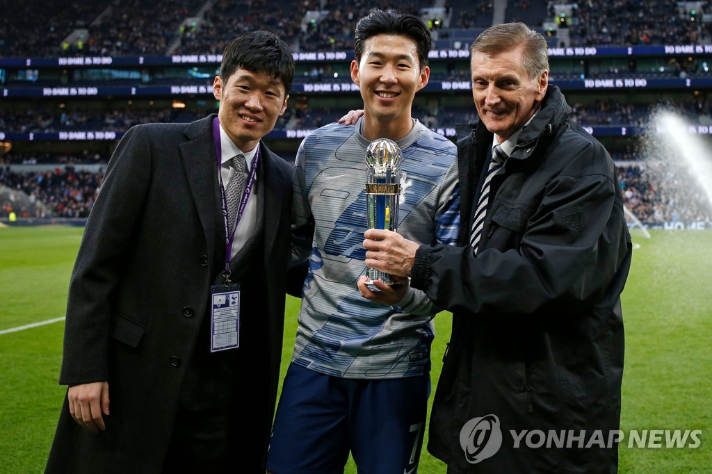 박지성(왼쪽)으로부터 'AFC 올해의 국제선수상' 트로피를 받은 손흥민(가운데)