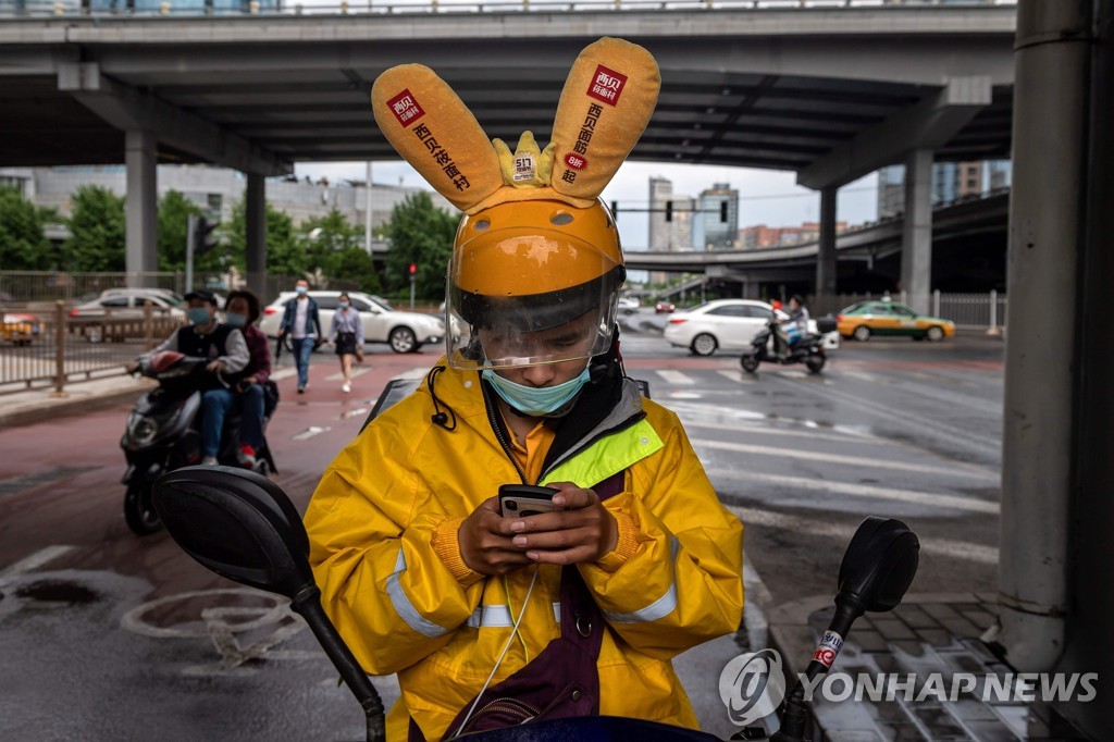 베이징의 음식 배달원이 스마트폰을 보고 있다. [AFP=연합뉴스 자료사진]