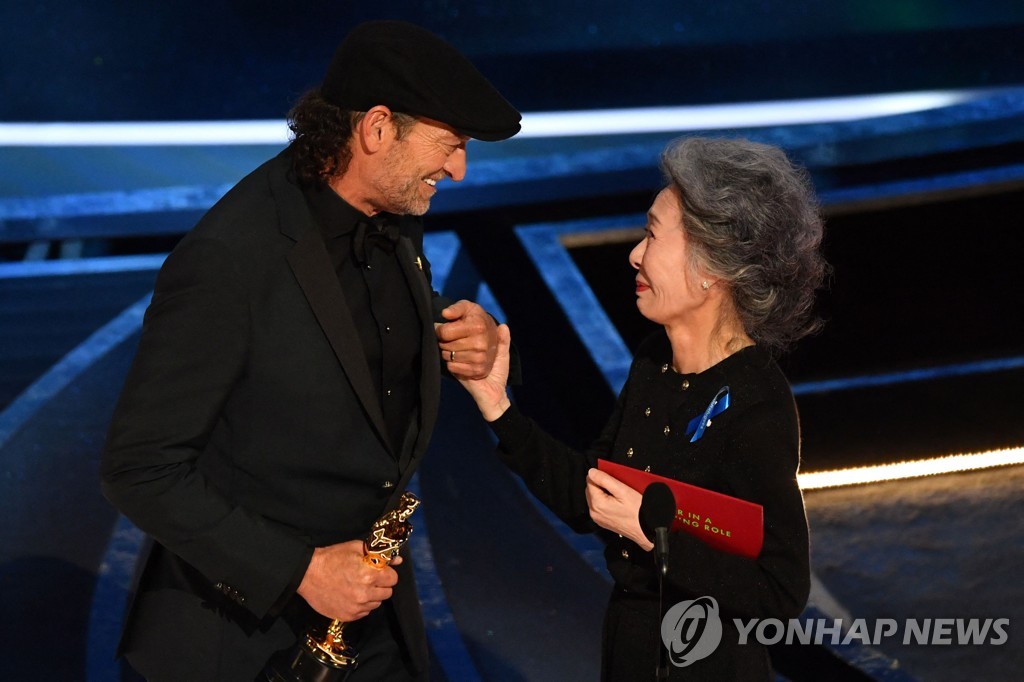 In this AFP photo, Troy Kotsur (L) accepts the Oscar for Best Actor in a Supporting Role for "CODA" onstage from presenter Youn Yuh-jung during the 94th Academy Awards in Hollywood, California, on March 27, 2022. (Yonhap)