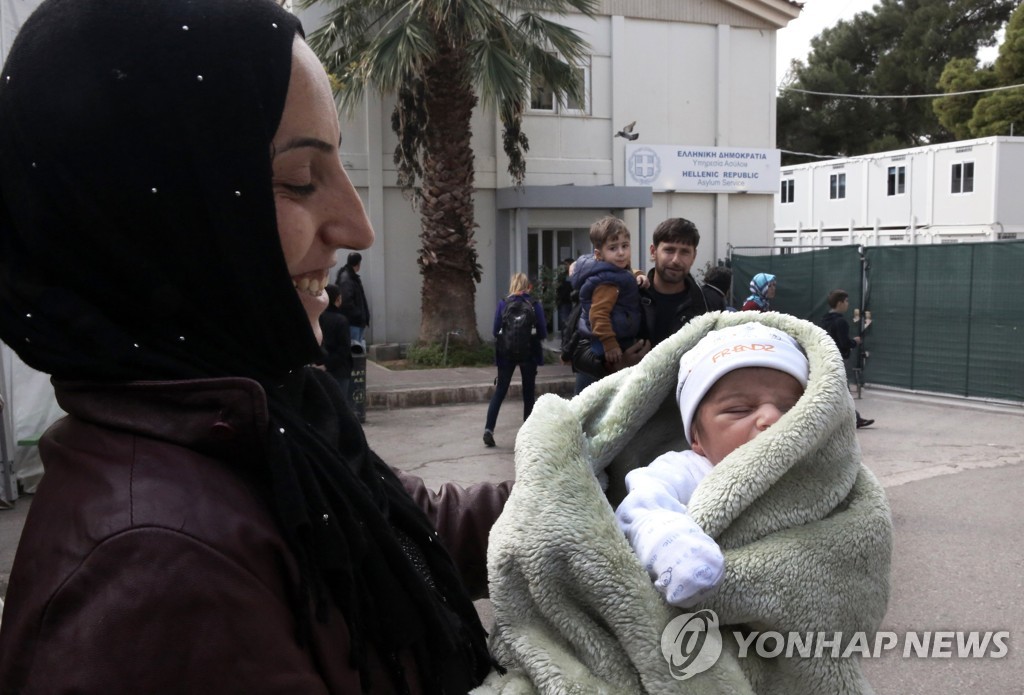 시리아에서 그리스로 건너온 이주민이 생후 15일된 아기를 안고 있는 모습. (사진은 기사 내용과 관련 없음) [EPA=연합뉴스 자료사진]