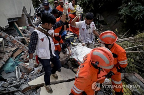지난달 30일 인도네시아 강진·쓰나미 생존자 옮기는 구조대원들[EPA=연합뉴스]