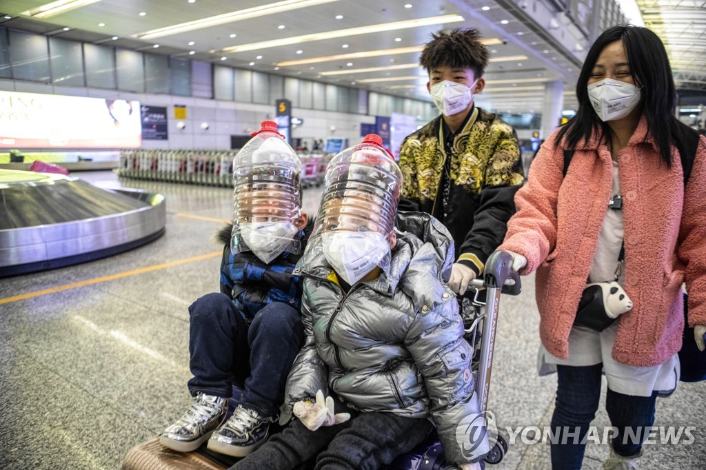  1일 마스크 대용으로 플라스틱 병을 쓰고 중국 광저우 공항으로 도착하는 아이들