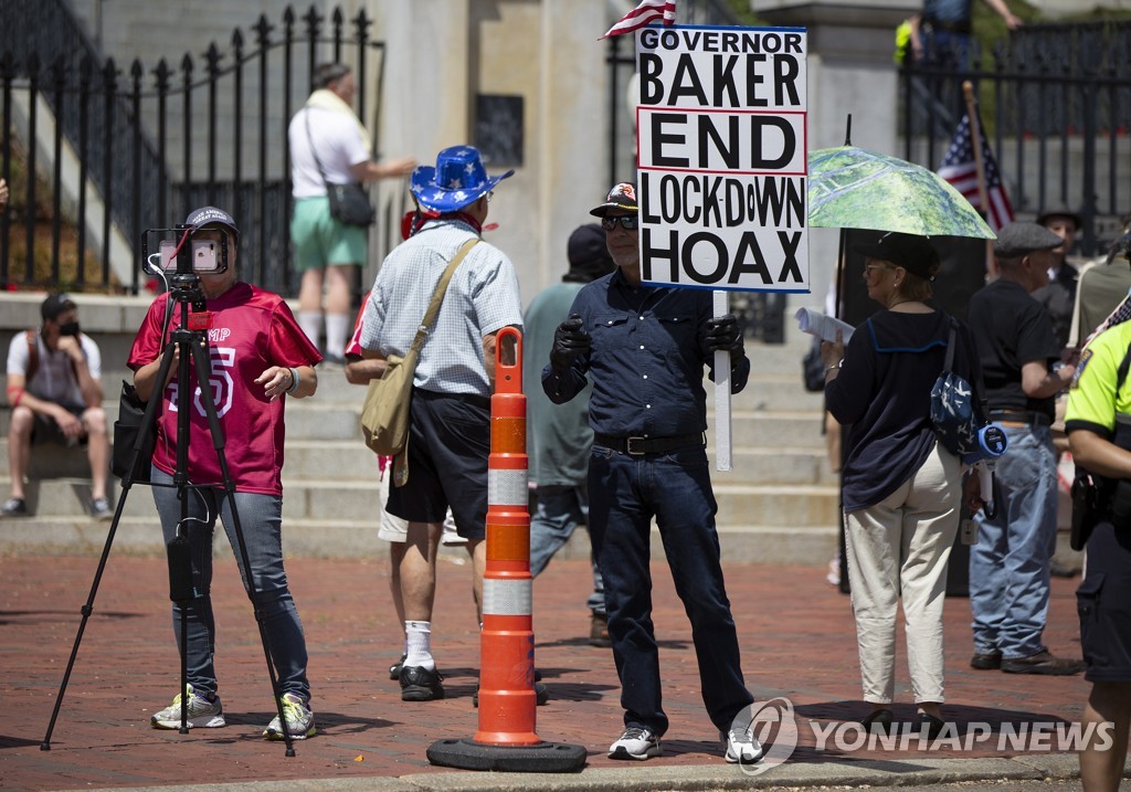지난 5월 30일 미국 매사추세츠주 보스턴에서 한 시위자가 "정부는 경제 폐쇄라는 거짓말을 끝내라"는 문구가 적힌 팻말을 들고 경제 활동을 재개하라고 요구하고 있다.[EPA=연합뉴스 자료사진]