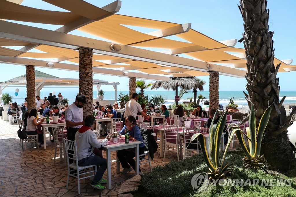 지난 8일(현지시간) 이탈리아 로마 근처의 한 해변에서 사람들이 식당에 있는 모습. [EPA=연합뉴스 자료사진]