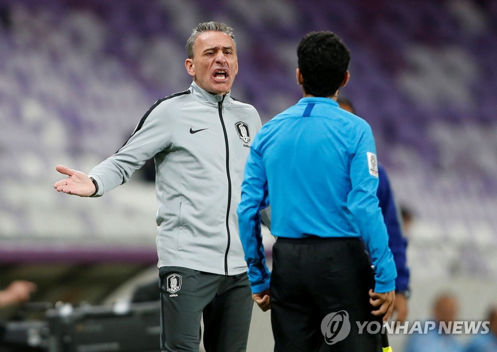 In this Reuters photo, Paulo Bento (L), head coach of the South Korean men's football team, speaks with referee Khamis Al Marri during a Group C match against Kyrgyzstan at the Asian Football Confederation Asian Cup at Hazza Bin Zayed Stadium in Al Ain, the United Arab Emirates, on Jan. 11, 2019. (Yonhap)