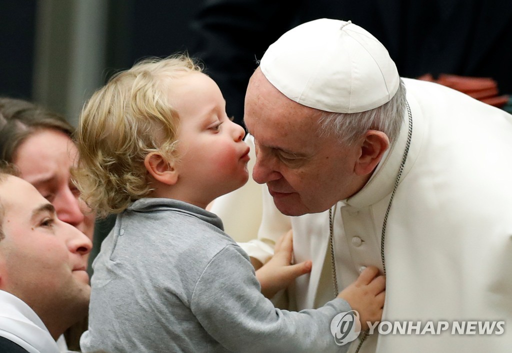 22일(현지시간) 바티칸 성베드로 대성당에서 열린 수요 일반 알현에서 어린이의 볼키스를 받는 프란치스코 교황. [로이터=연합뉴스]