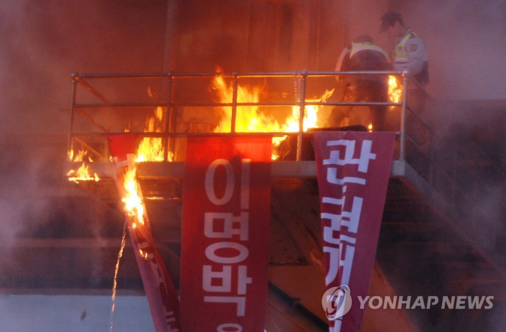 지난 2월 서울역 고가도로 밑에서 시민사회단체 활동가 김모(47)씨가 자신의 몸에 인화성 물질을 뿌리고 불을 붙였다. 분신 시도 직후 김씨의 몸에 붙은 불을 진화하는 경찰의 모습. (연합뉴스 자료사진)
