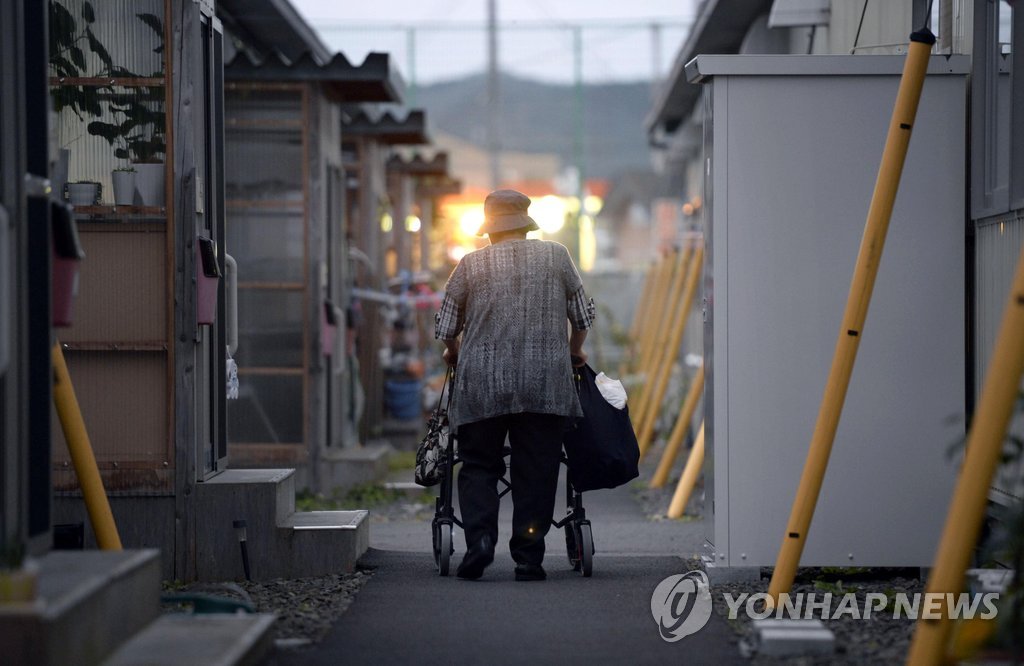 (도쿄 교도=연합뉴스.자료사진) 2014년 9월 일본 대지진 피해지역인 미야기 현의 한 가설주택 단지에서 걸어가는 노인의 모습.