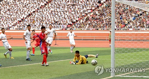 지난해 8월 24일 북한 평양 능라도 5.1경기장에서 열린 2015 제2회 국제 유소년 U-15(15세 이하) 축구대회 결승전 4.25체육단(붉은유니폼)과 평양국제축구학교의 결승전에서 4.25 체육단 선수가 골을 넣고 있다. <<연합뉴스 DB>>