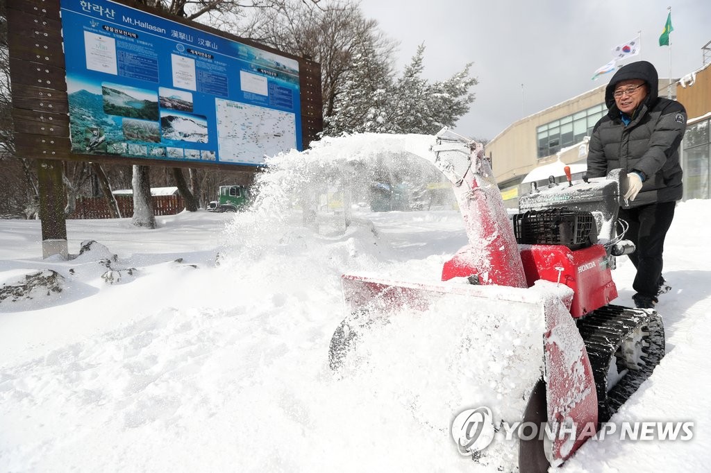 '치워도 끝이 없는 눈' (제주=연합뉴스) 박지호 기자 = 폭설이 내린 10일 오전 제주 한라산 국립공원 성판악 탐방 안내소에서 안내소 직원이 제설기를 이용해 눈을 치우고 있다. 2017.2.10 jihopark@yna.co.kr