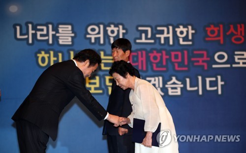 호국보훈의 달 표어 앞에서 포상하는 이낙연 총리