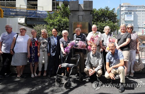 참전기념비 앞에 선 스웨덴병원 의료진과 가족들