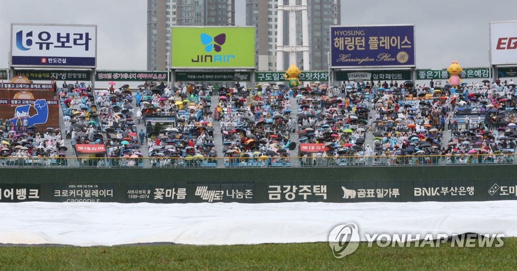 우산 쓰고 기다리는 야구팬들