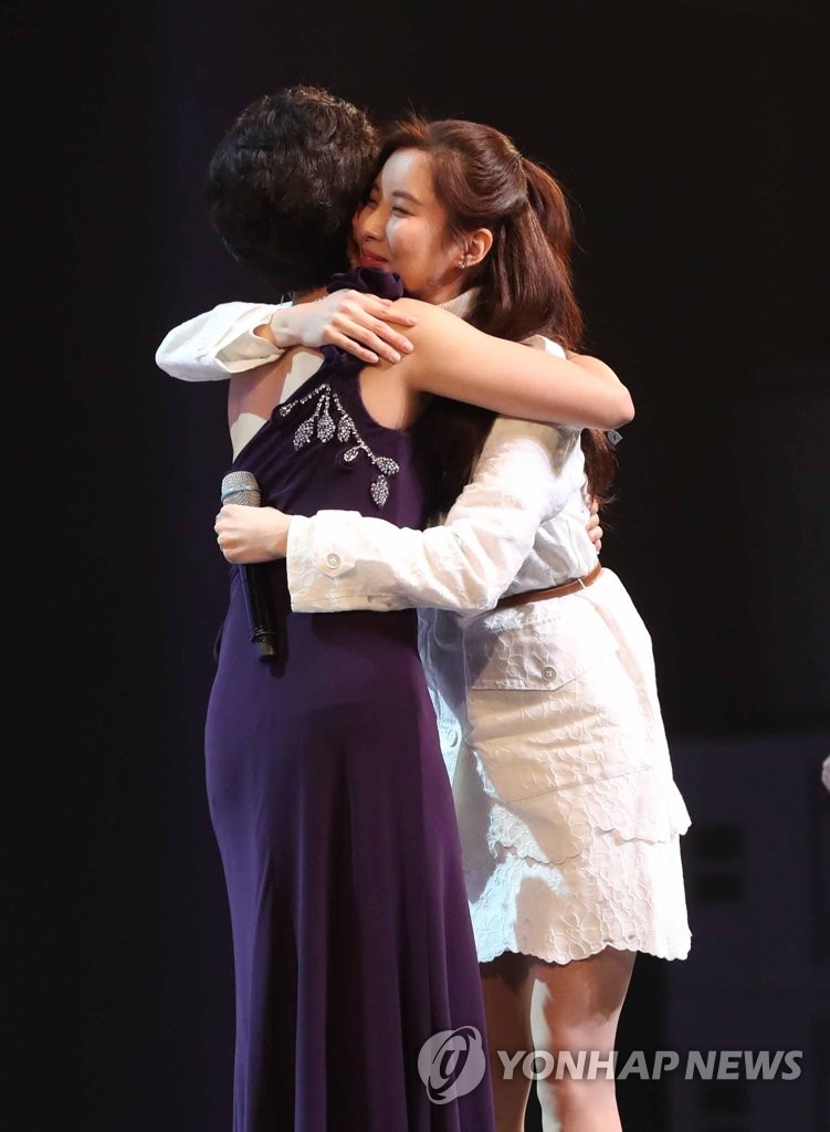 １１日夜、ソウルで開かれた北朝鮮芸術団の公演で歌った後、北朝鮮の歌手と抱き合うソヒョン（右、資料写真）＝（聯合ニュース）