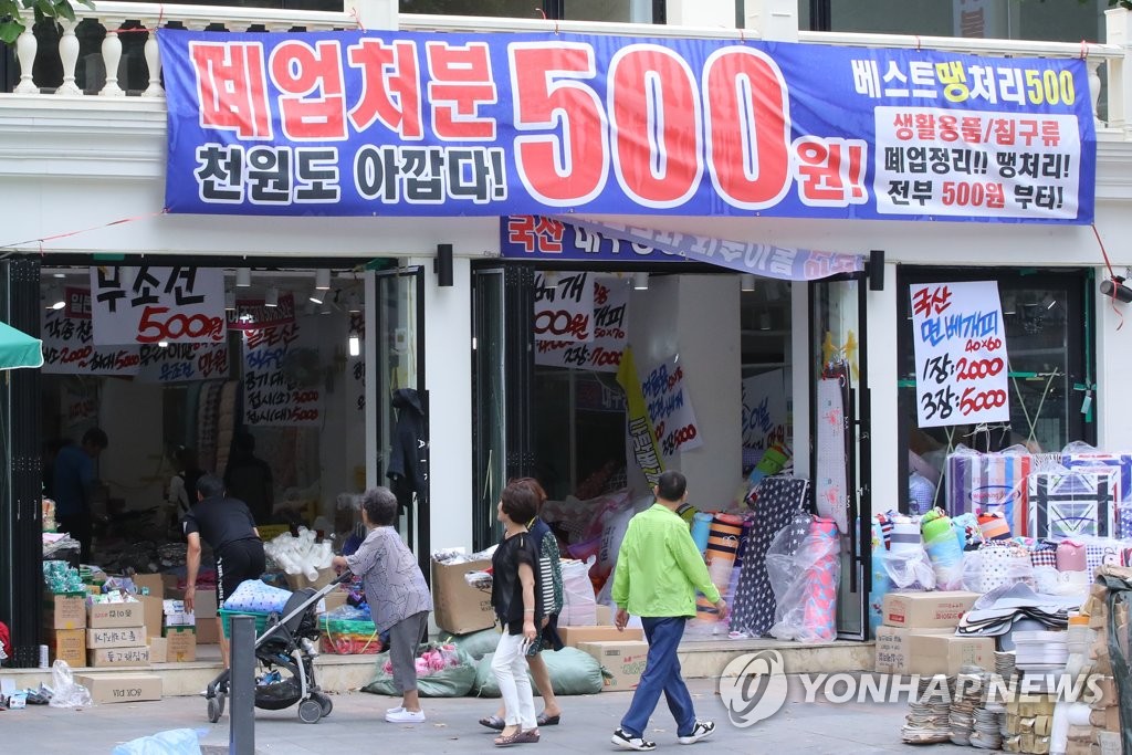 2018년 6월 10일 서울 종로구의 한 매장에 '폐업 처분'이라고 쓴 현수막이 붙어 있다. 정부는 소상공인이 겪는 어려움을 완화할 대책을 8월 중 발표할 계획이다. [연합뉴스 자료사진]