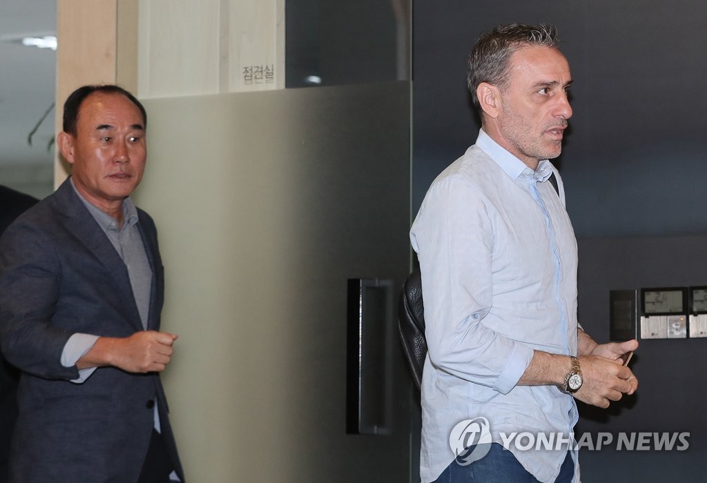 South Korea's senior national football team head coach Paulo Bento (R) and under-23 team head coach Kim Hak-bum enter a meeting room at the Korea Football Association (KFA) House in Seoul on Sept. 20, 2018. (Yonhap)