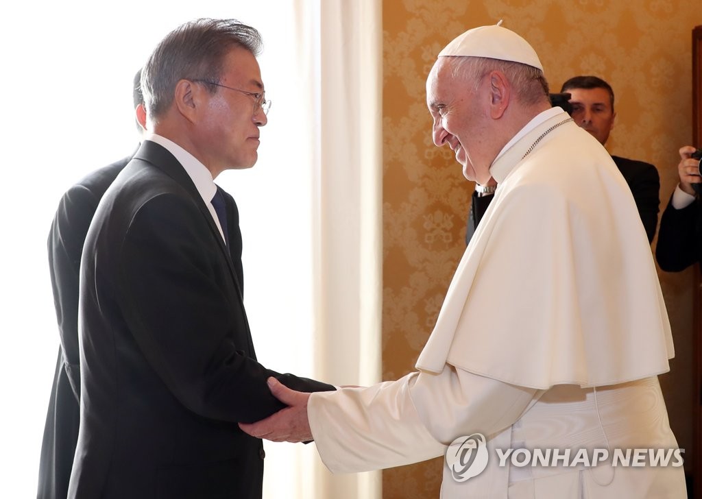 South Korean President Moon Jae-in (L) holds hands with Pope Francis while paying a courtesy call on the pontiff in the Vatican on Oct. 18, 2018. (Yonhap)