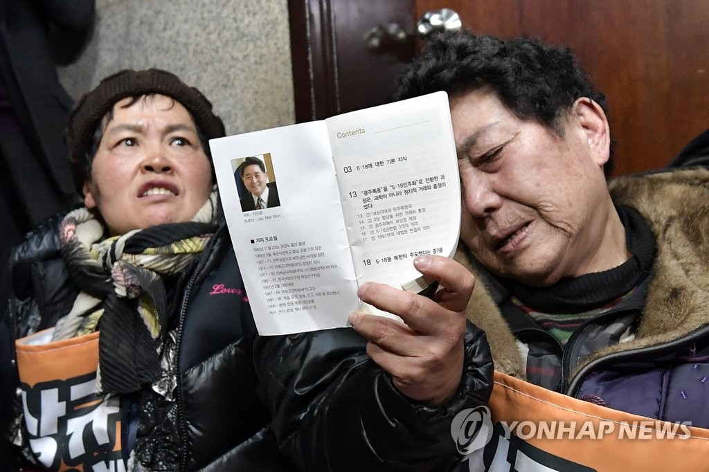 '지만원 씨가 배포한 책자를 들고'