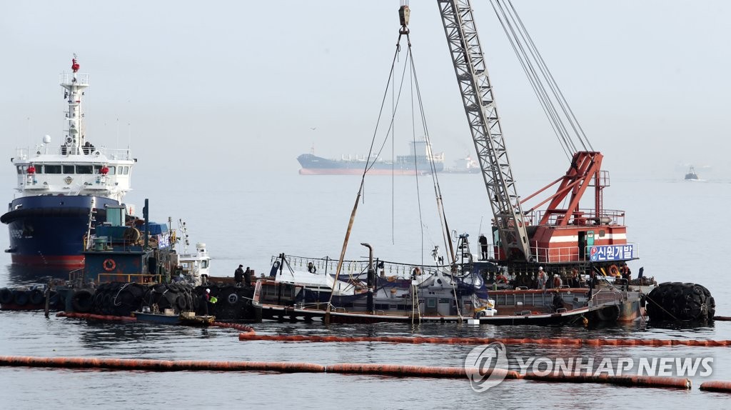 Capsized fishing boat towed Capsized fishing boat towed
