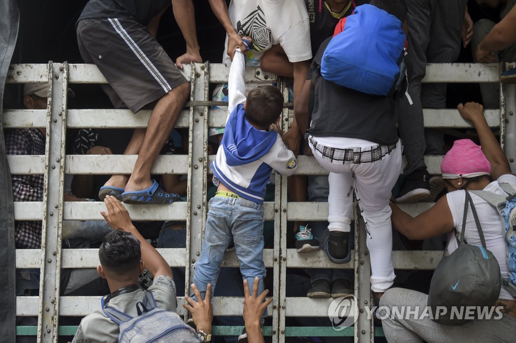 '받치고, 당기고…'…힘겹게 트럭 오르는 베네수엘라 난민
