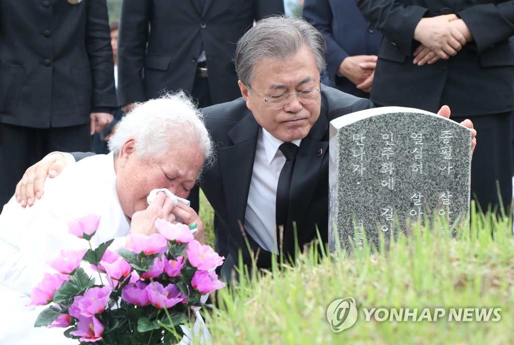 President Moon Jae-in (R) consoles a bereaved family member of a victim of the 1980 civilian massacre committed by a military junta during the May 18 Democratization Movement in Gwangju while visiting a national cemetery there on May 18, 2019. (Yonhap)