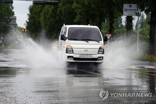 장맛비에 물보라를 일으키며 지나가는 차량