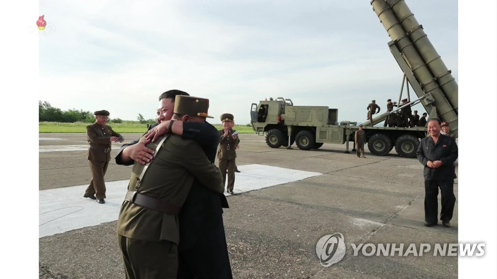 '초대형 방사포' 발사 관계자 안아주는 김정은