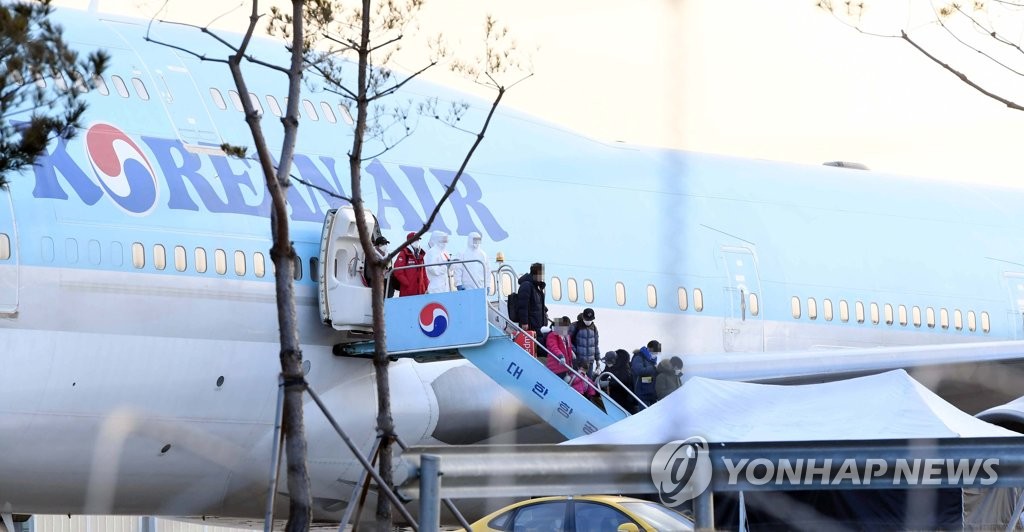 South Korean evacuees from the coronavirus-hit Chinese city of Wuhan disembark from a chartered flight after arriving at Gimpo International Airport in Seoul on Jan. 31, 2020. South Korea's first evacuation plane brought back 368 nationals, and those with no symptoms were to be isolated at two state facilities for two weeks. (Yonhap)