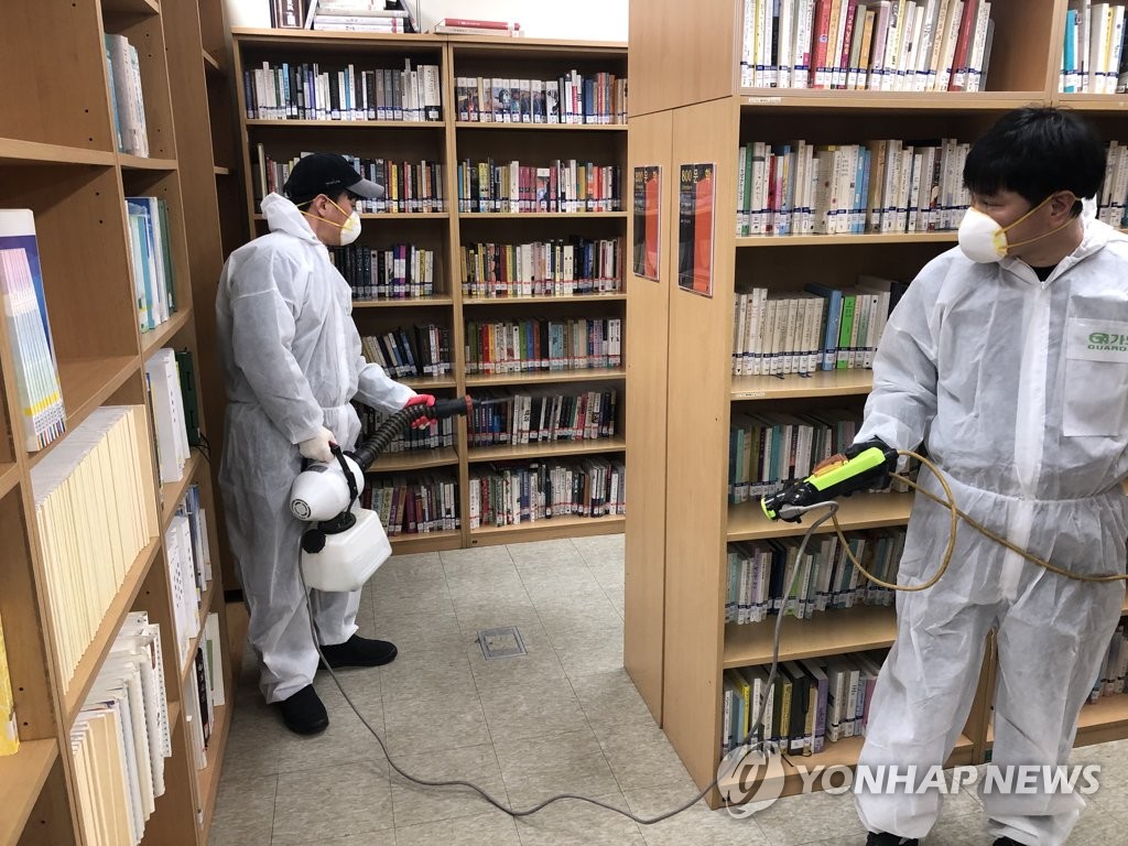 Quarantine workers in protective suits and masks disinfect a library in Seongdong Ward in Seoul on Feb. 16, 2020, in this photo provided by the ward office. (PHOTO NOT FOR SALE) (Yonhap)