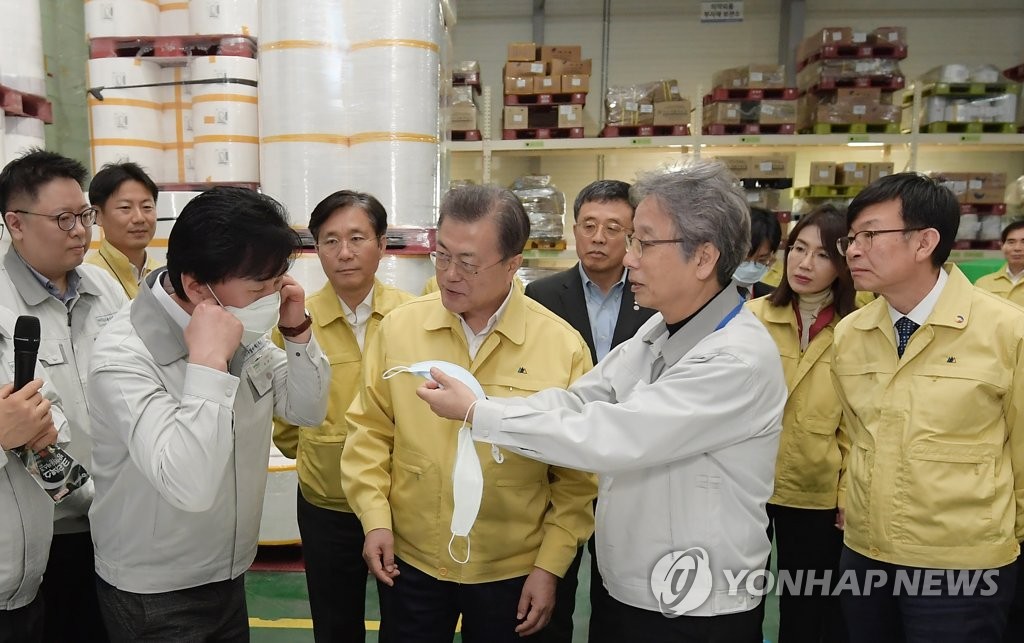 President Moon Jae-in (C) visits Wooil C&Tech Corp., a face mask-producing company in Pyeongtaek, south of Seoul, on March 6, 2020, and looks around its storage of mask materials. (Yonhap)