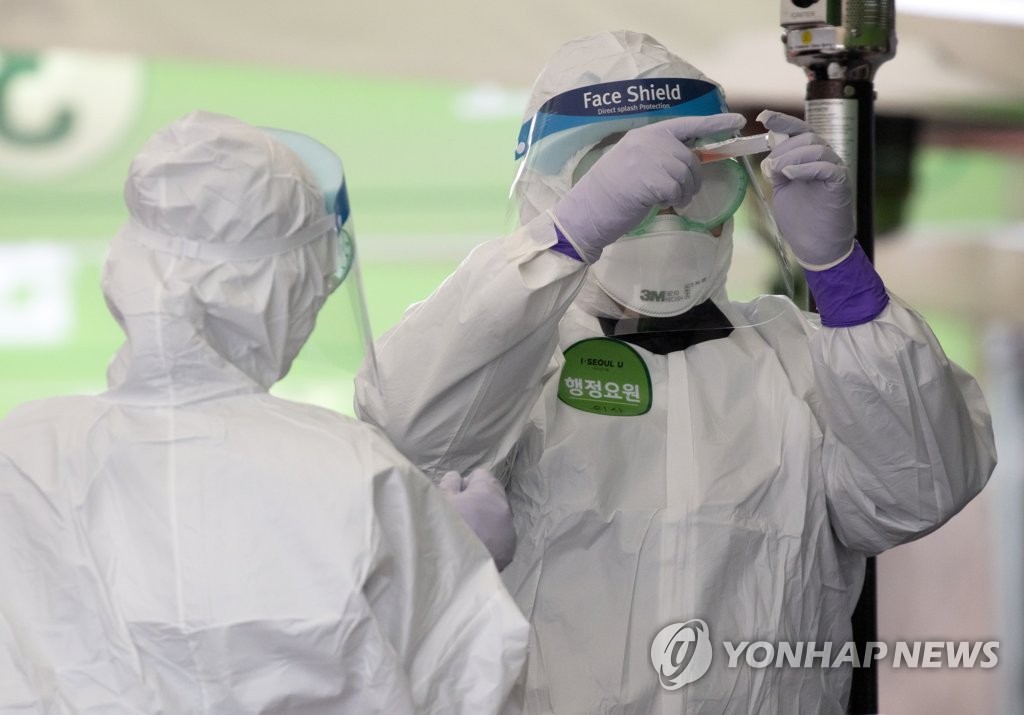 Medical workers collect samples for tests on the new coronavirus at a drive-through clinic in eastern Seoul on March 10, 2020. (Yonhap)