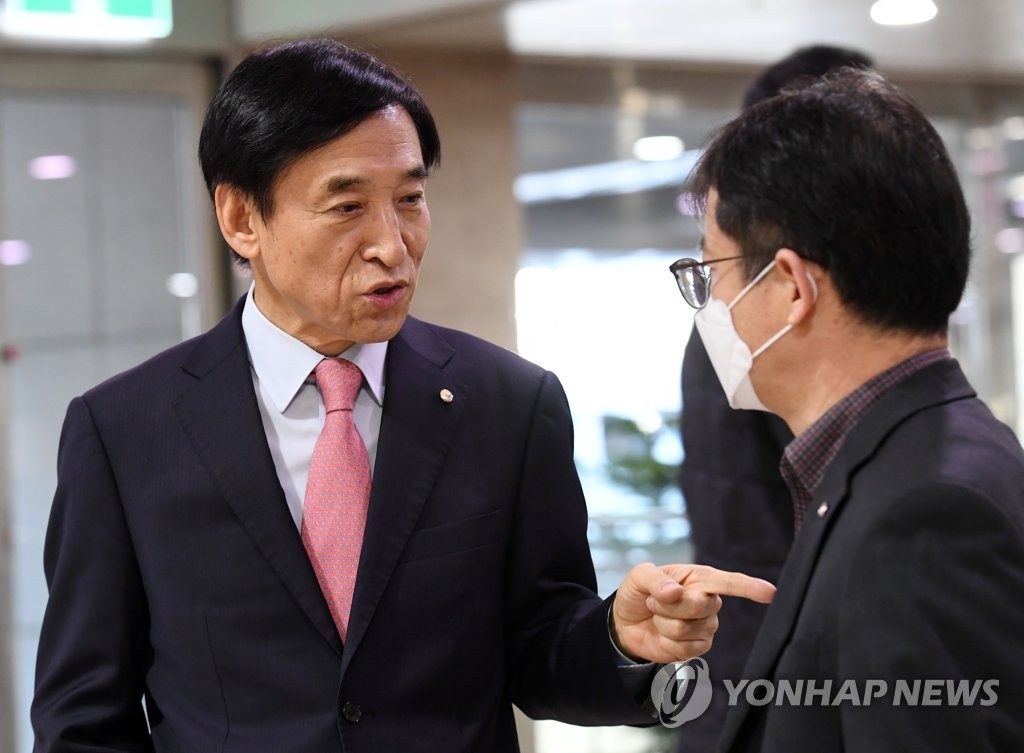 Bank of Korea (BOK) Gov. Lee Ju-yeol (L) speaks with a BOK official after meeting with journalists at the central bank building in Seoul on March 20, 2020. (Yonhap)