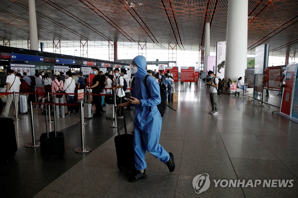 베이징 국제공항의 코로나19 방호복 입은 여행객