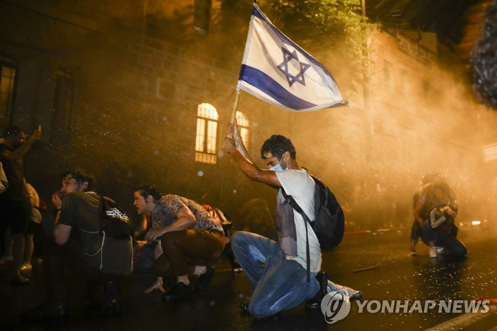 경찰 물대포에 맞서는 이스라엘 시위대
